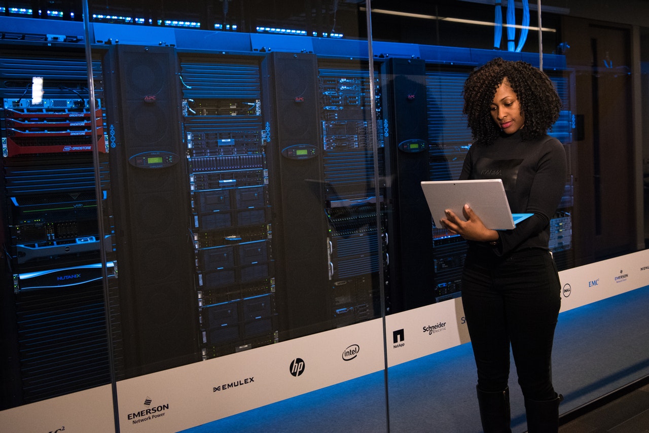 image of a women on her laptop in a server room