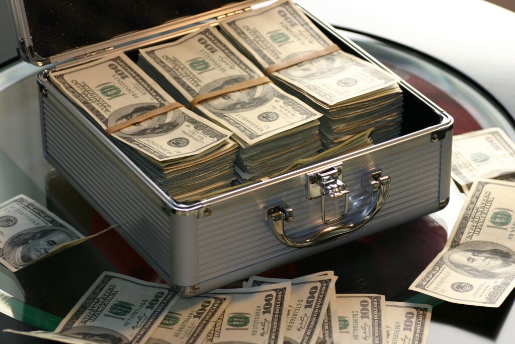 Money in and scattered around a briefcase